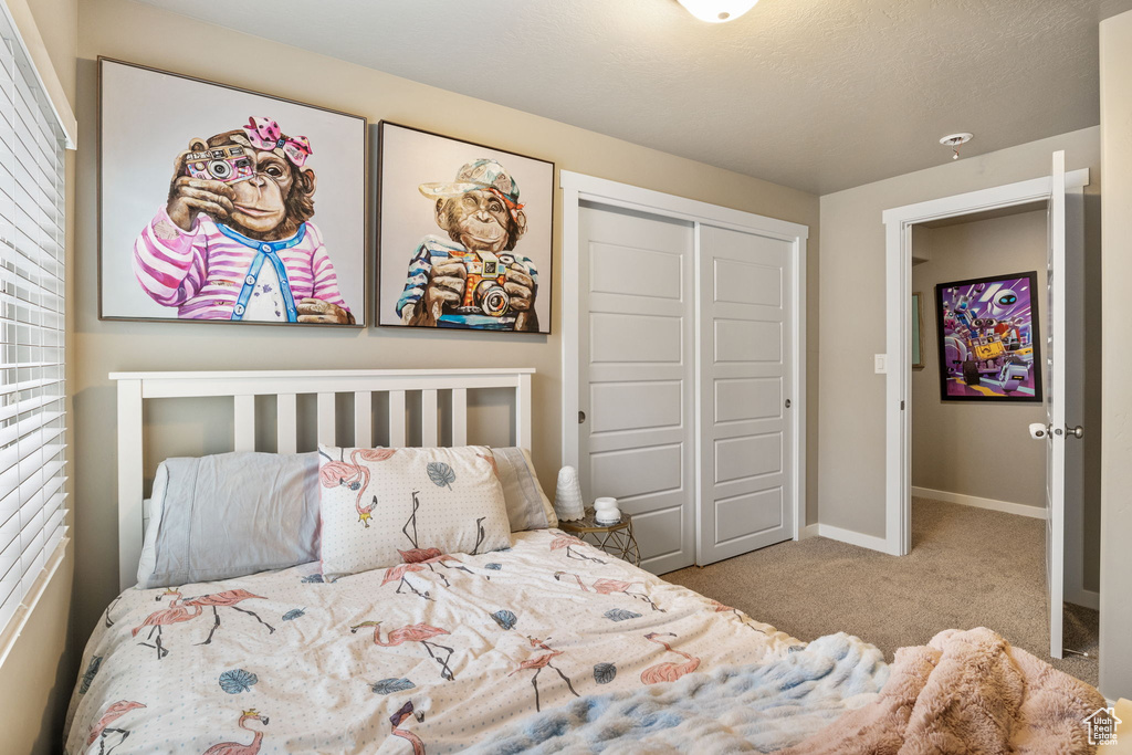 Carpeted bedroom featuring a closet and baseboards
