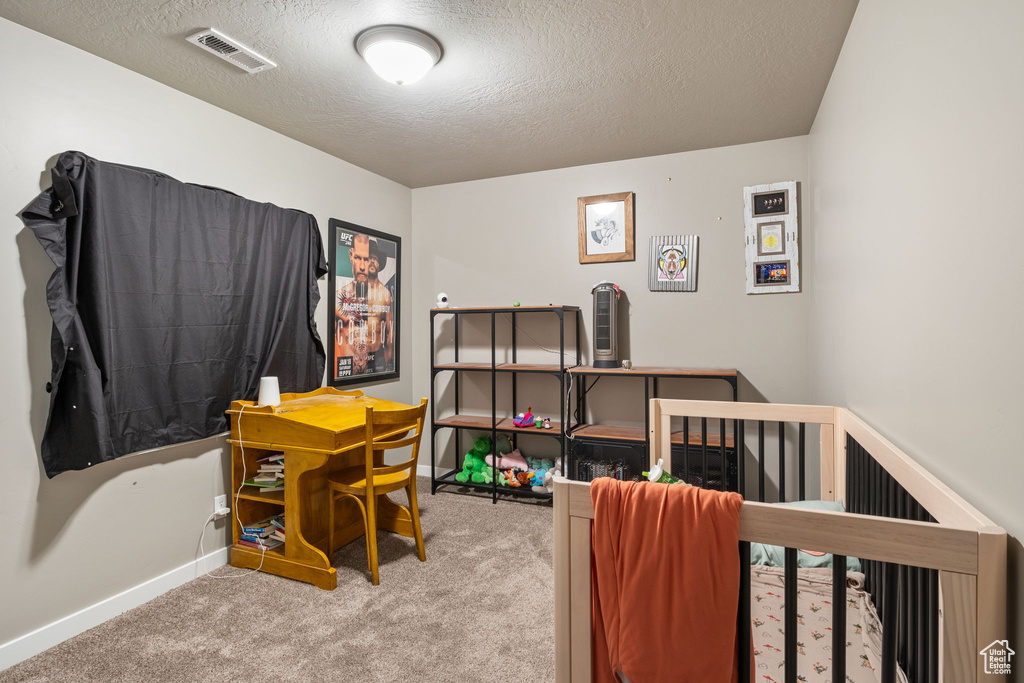 Bedroom featuring carpet floors and a textured ceiling