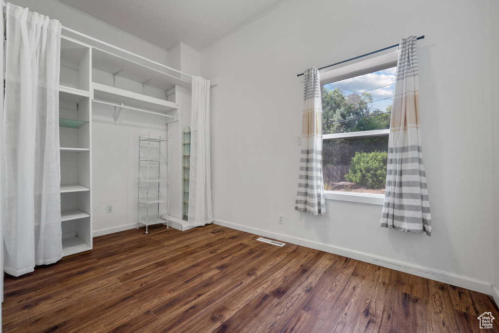 Unfurnished bedroom with multiple windows and wood finished floors