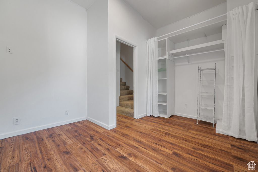 Unfurnished bedroom with dark wood finished floors and baseboards
