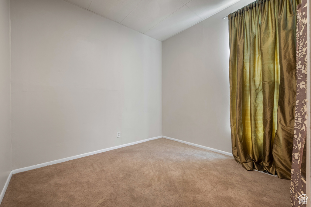 Empty room with lofted ceiling and light colored carpet