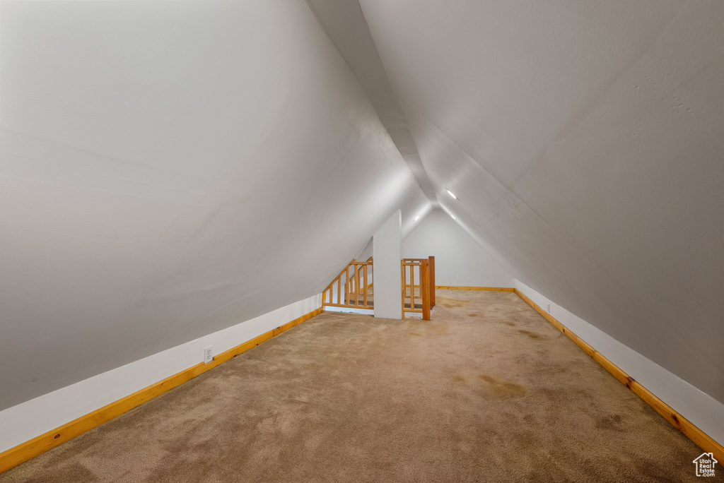 Additional living space with lofted ceiling and carpet floors
