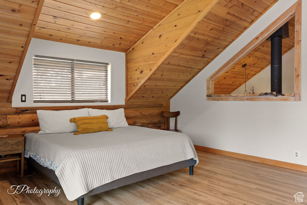 Bedroom with rustic walls, lofted ceiling, wood finished floors, and wood ceiling
