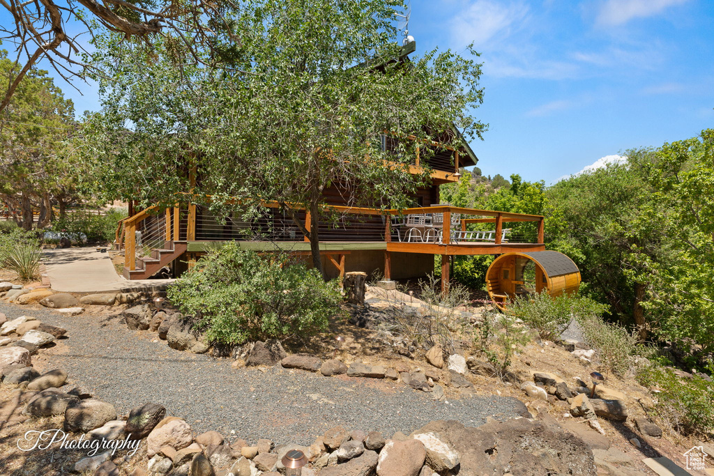 Rear view of property featuring log exterior, a deck, and stairs