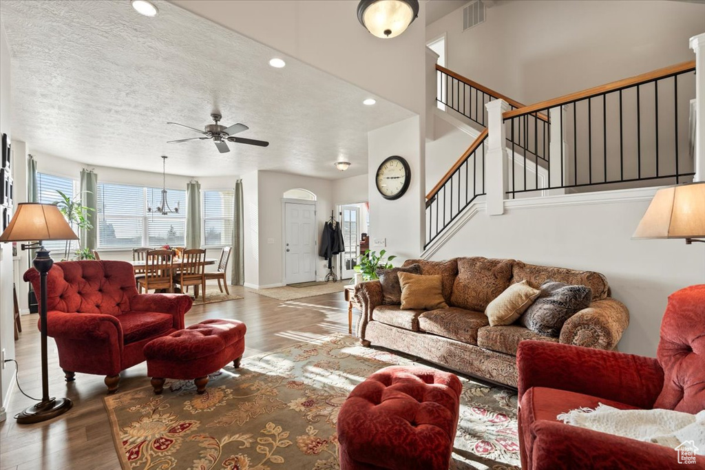 Living area with ceiling fan, wood finished floors, stairs, recessed lighting, and a textured ceiling