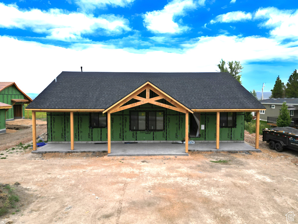 Property in mid-construction with a shingled roof and a porch