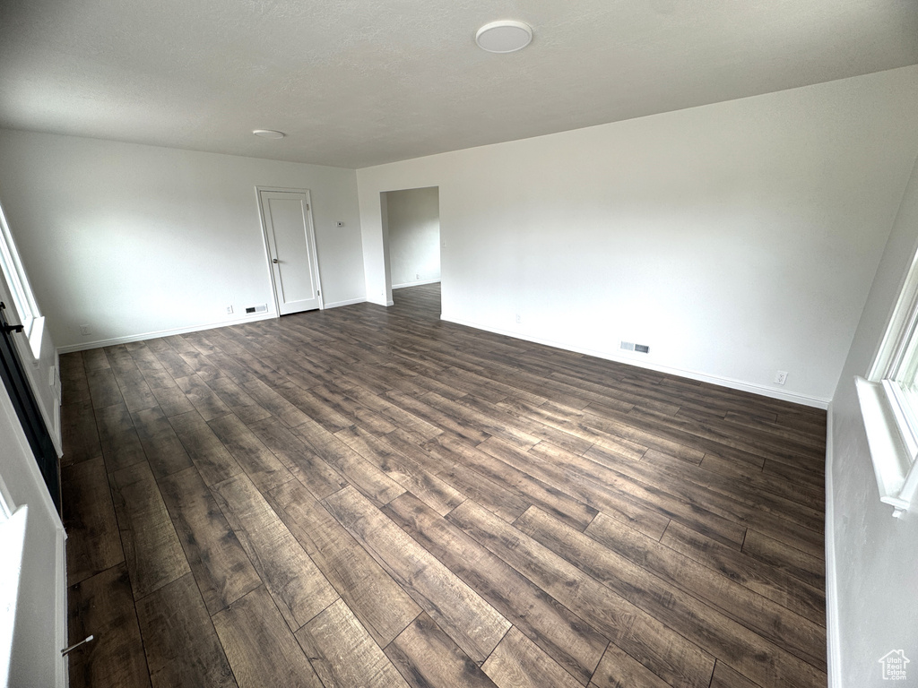 Spare room featuring dark wood-style floors