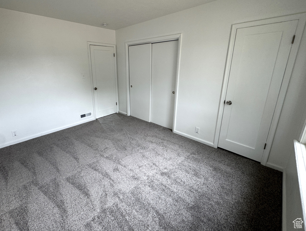 Unfurnished bedroom with carpet floors and baseboards