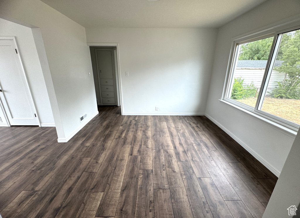 Unfurnished room featuring dark wood-style flooring