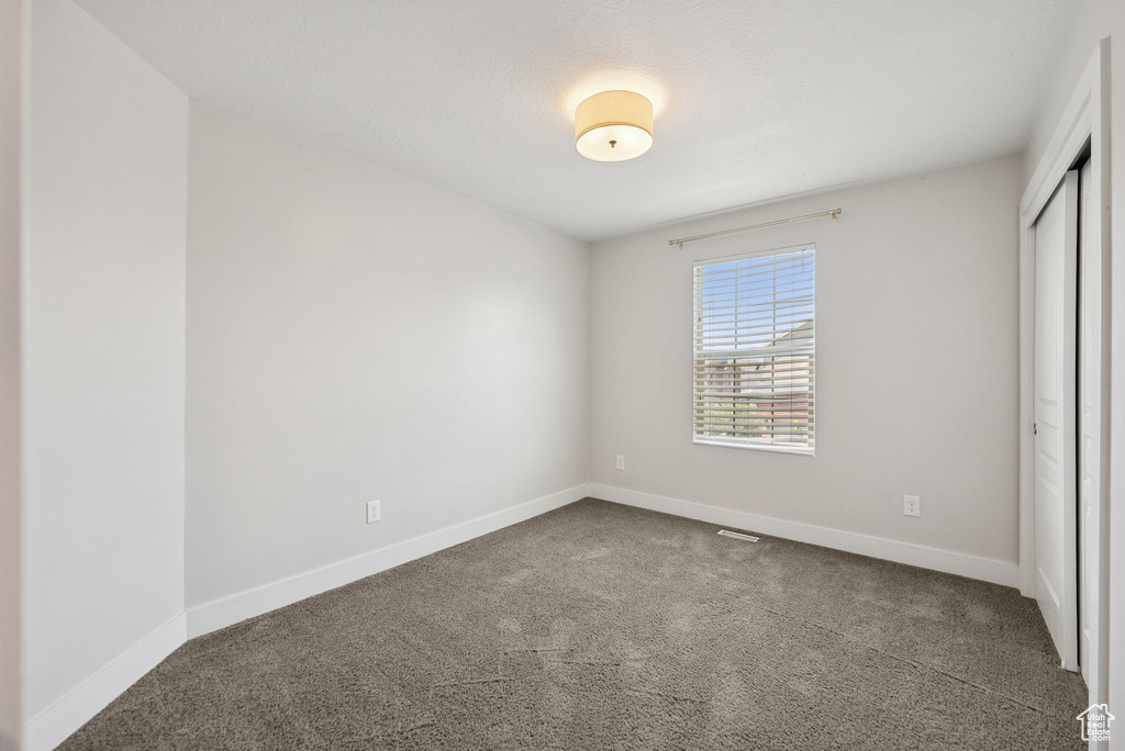 Unfurnished bedroom with carpet flooring and a closet