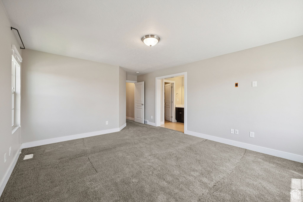 Carpeted empty room with baseboards