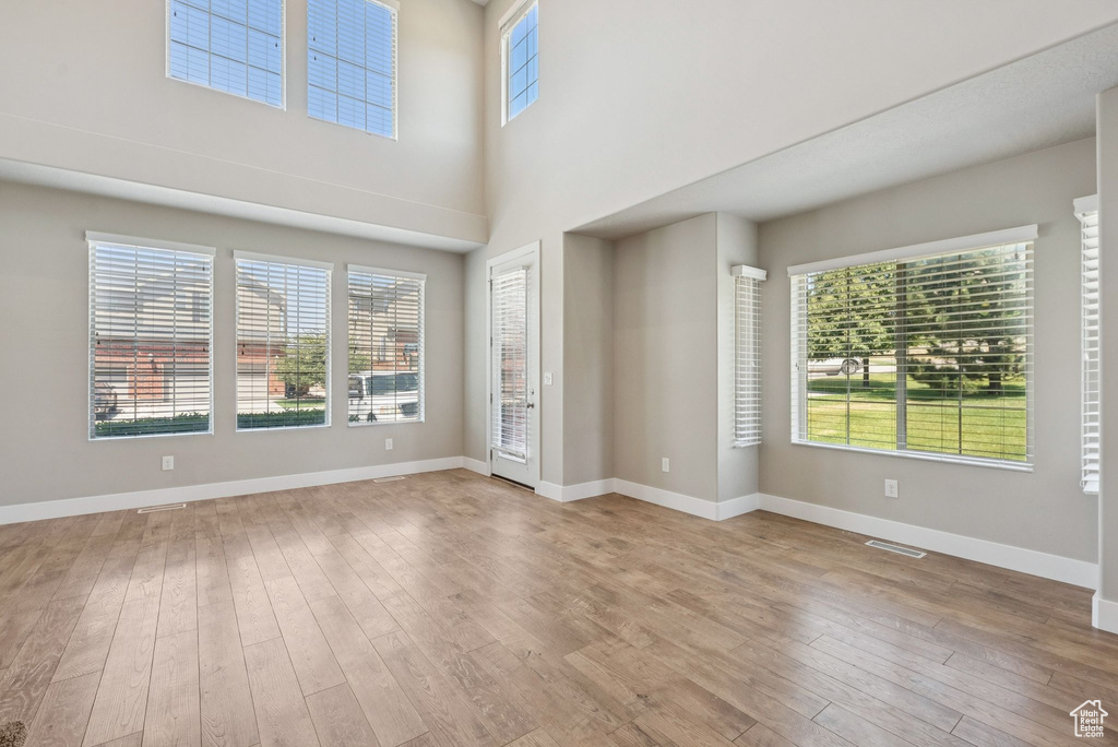 Spare room featuring hardwood / wood-style flooring and a towering ceiling