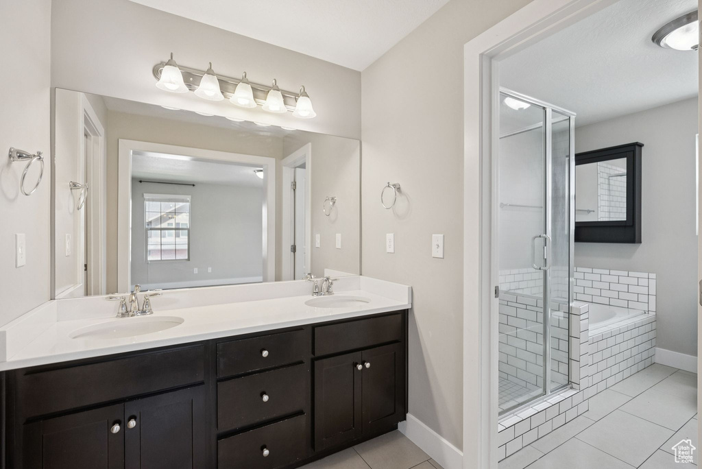 Full bathroom with a stall shower, double vanity, a bath, and tile patterned floors