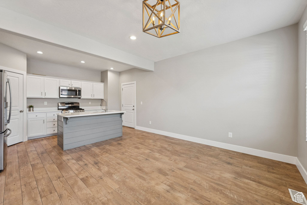 Kitchen featuring stainless steel appliances, a chandelier, light wood-style floors, light countertops, and recessed lighting