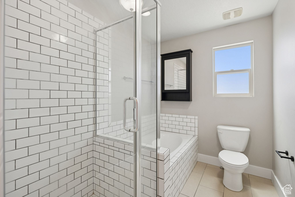 Bathroom featuring a garden tub, a stall shower, and tile patterned flooring