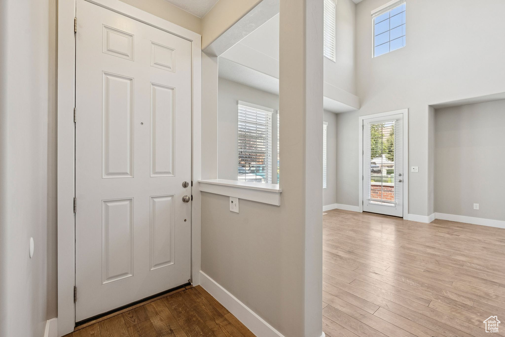 Entrance foyer featuring healthy amount of natural light, wood finished floors, and a towering ceiling