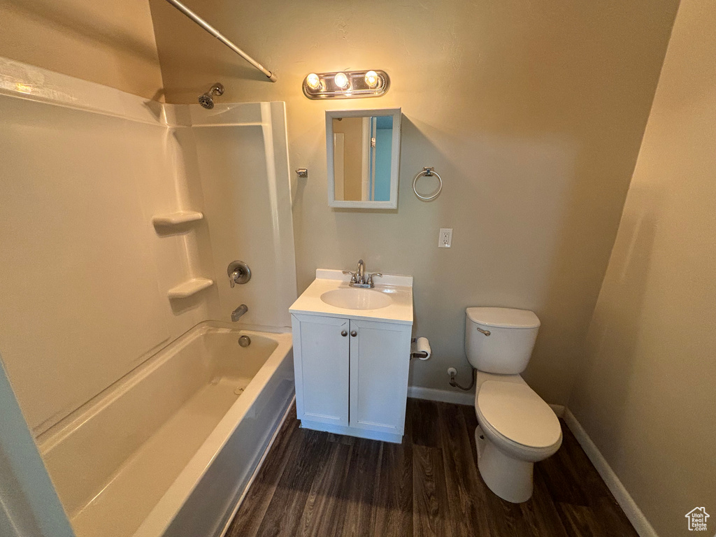 Bathroom featuring washtub / shower combination, wood finished floors, and vanity