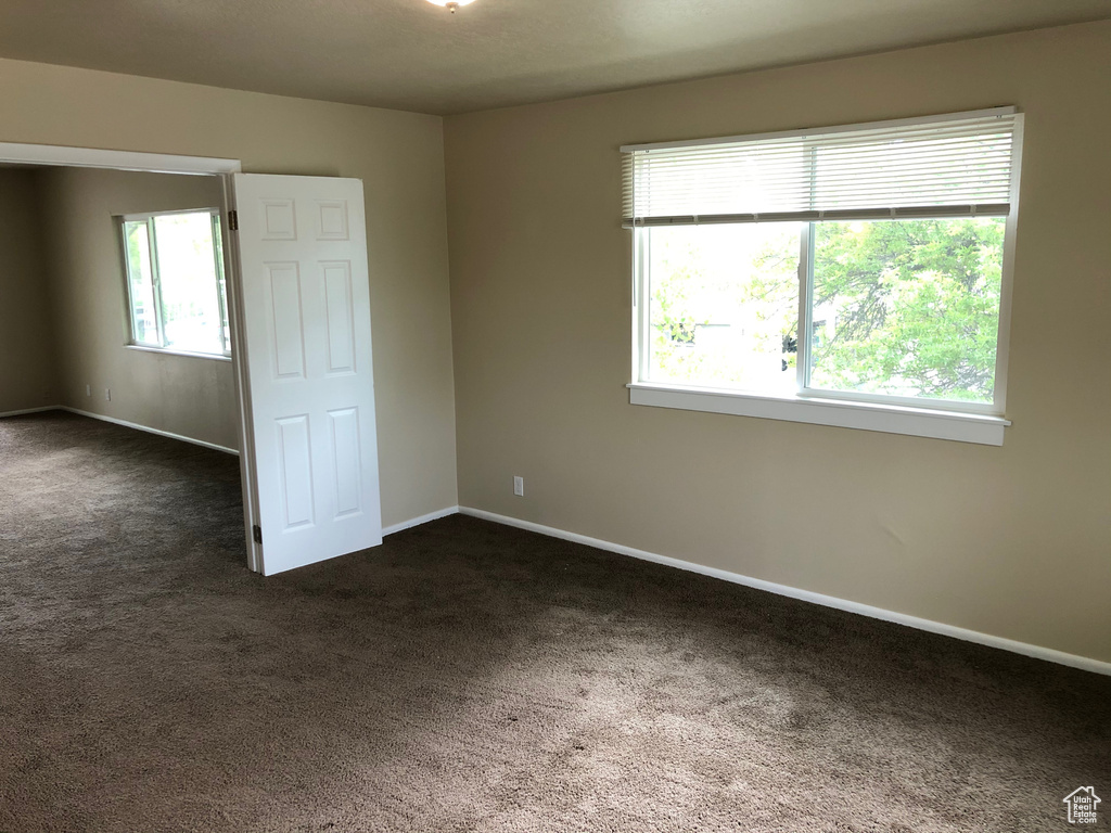 Unfurnished bedroom with dark colored carpet