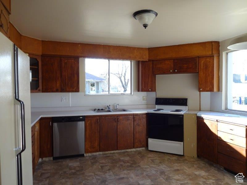 Kitchen with white appliances, light countertops, and plenty of natural light