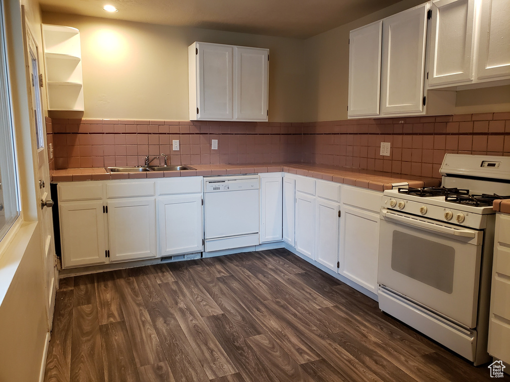 Kitchen with white appliances, tile countertops, white cabinetry, dark wood finished floors, and recessed lighting