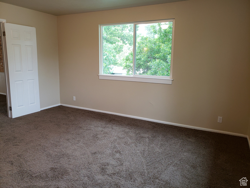Carpeted spare room with baseboards