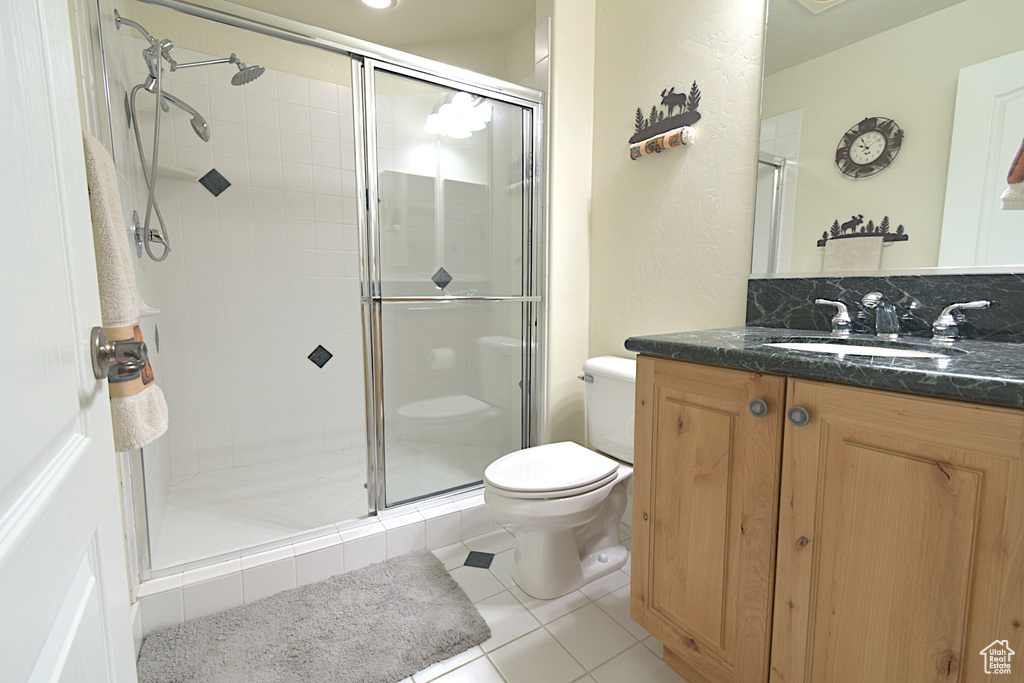 Bathroom with vanity, a shower stall, and tile patterned floors