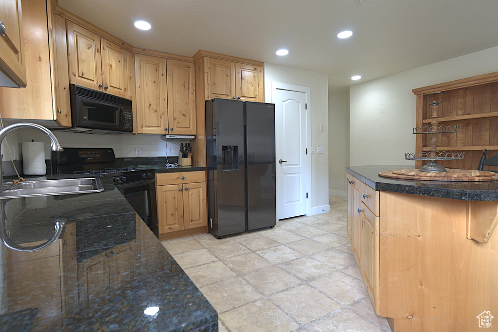 Kitchen with black appliances, recessed lighting, and light stone finish floors
