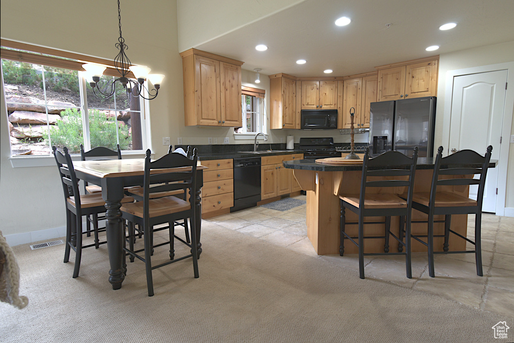Kitchen featuring black appliances, a chandelier, light brown cabinetry, recessed lighting, and dark countertops
