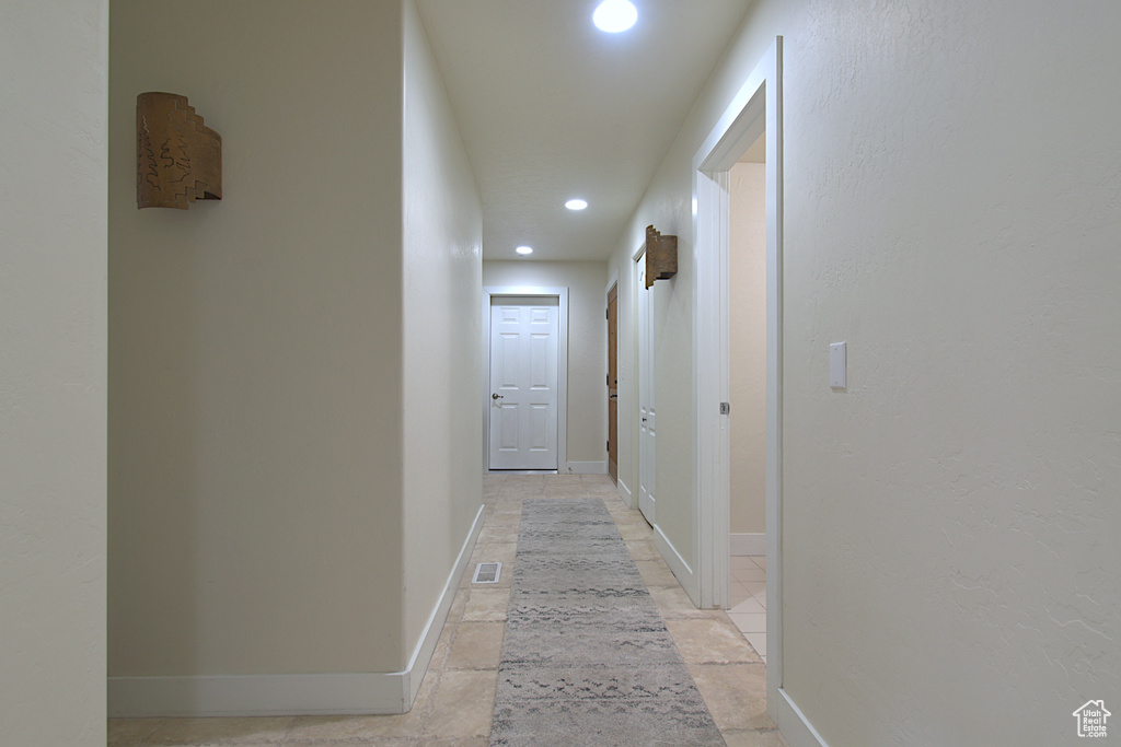 Hall with recessed lighting and baseboards