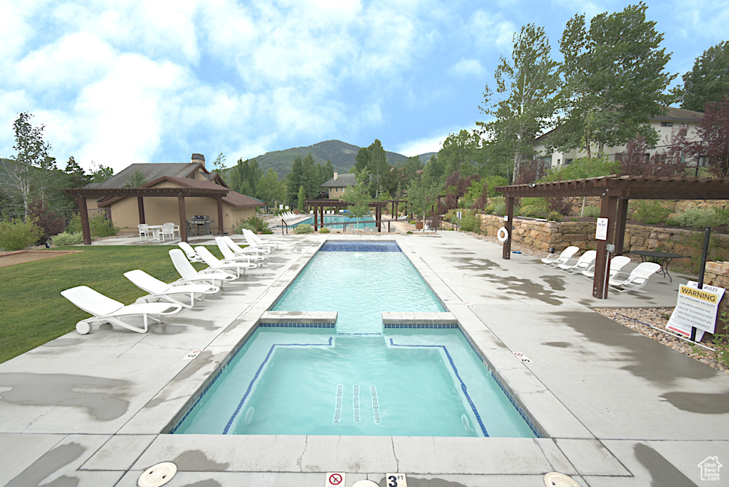 View of swimming pool featuring a pergola, a gazebo, a mountain view, a patio area, and a pool with connected hot tub