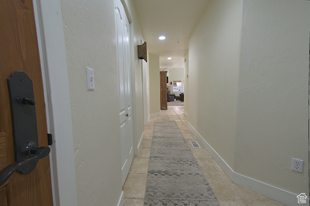 Corridor with a textured wall and recessed lighting