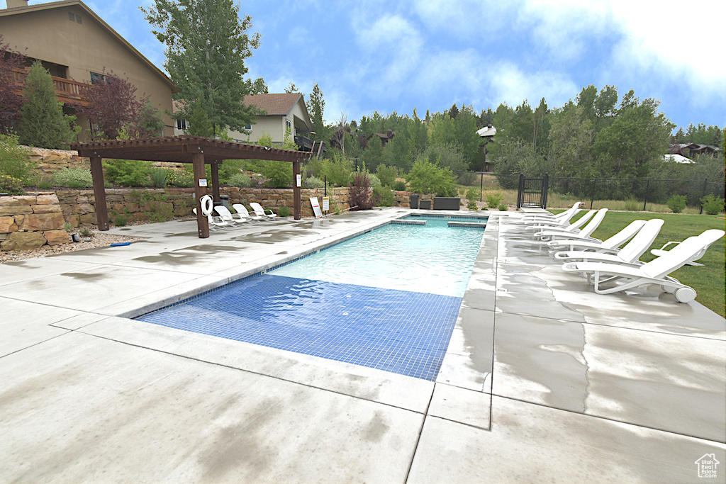 Community pool featuring a pergola and a patio area