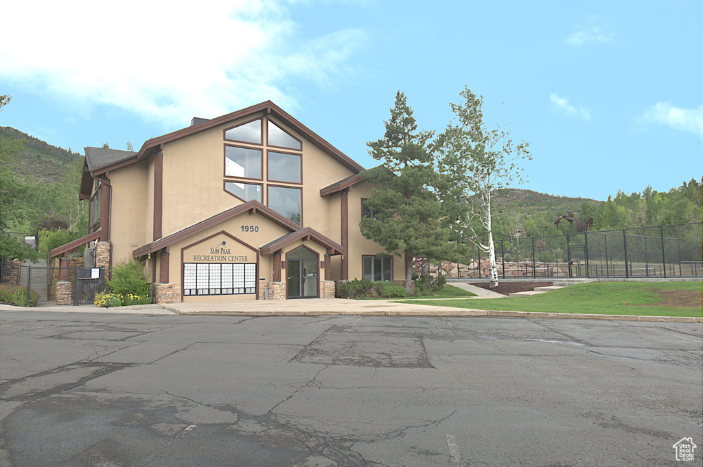 View of front facade featuring stone siding, stucco siding, an attached garage, and driveway