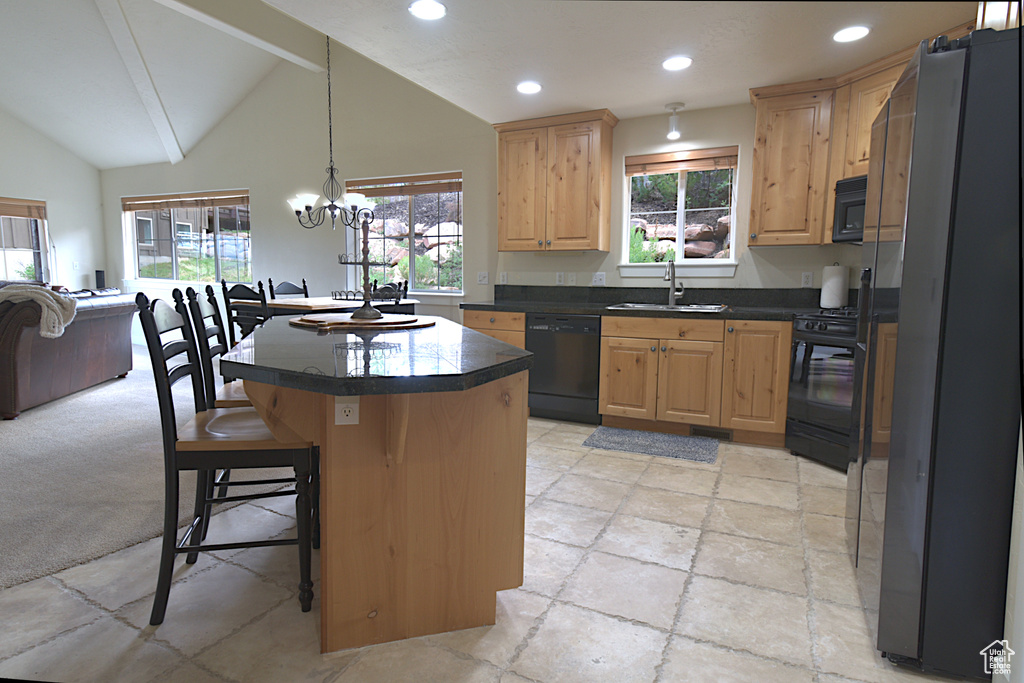 Kitchen with black appliances, light brown cabinets, dark countertops, a kitchen bar, and recessed lighting