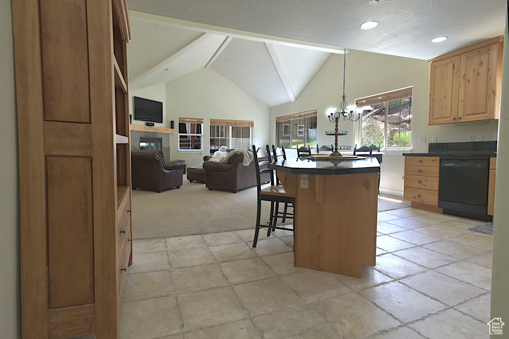 Kitchen featuring black dishwasher, dark countertops, a kitchen bar, a chandelier, and stone tile floors
