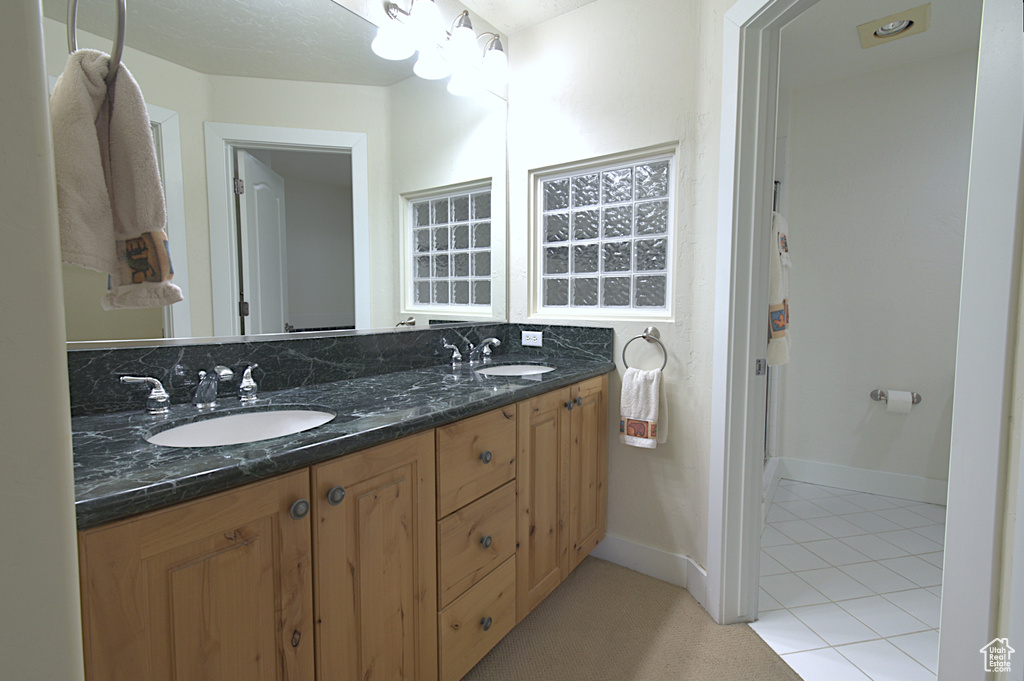 Bathroom with double vanity and tile patterned flooring