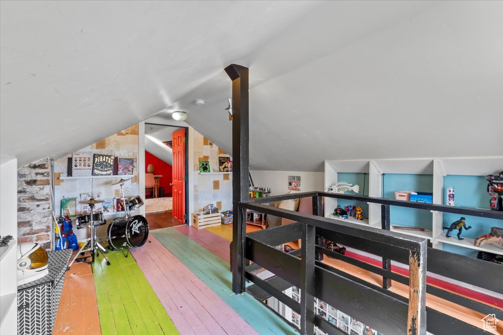 Recreation room with hardwood / wood-style floors and vaulted ceiling