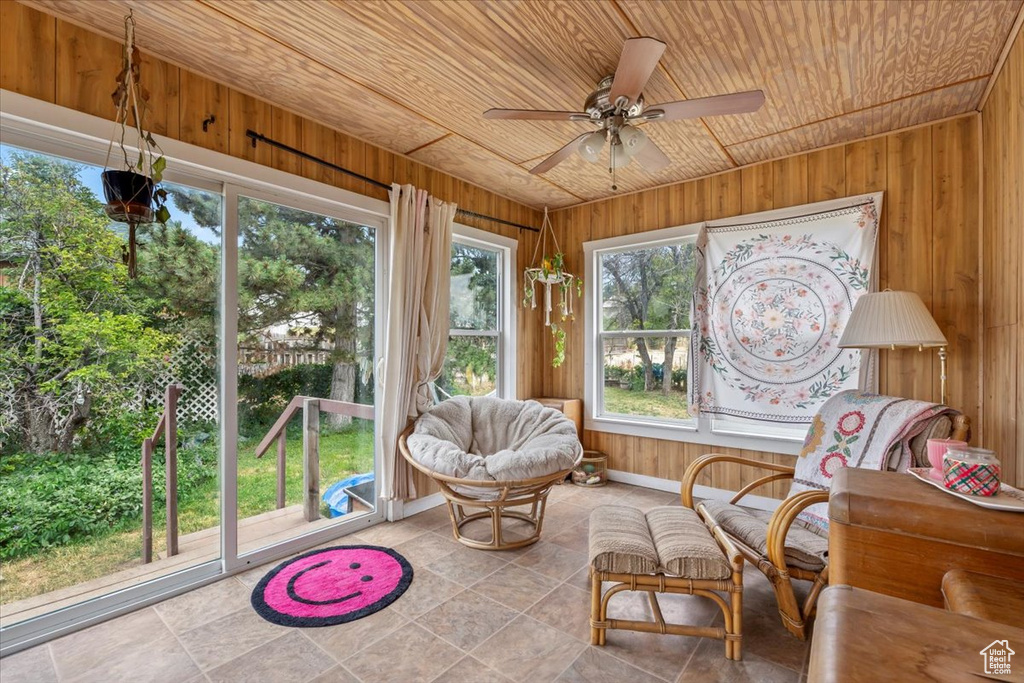 Sunroom with wooden ceiling, wooden walls, and tile patterned floors