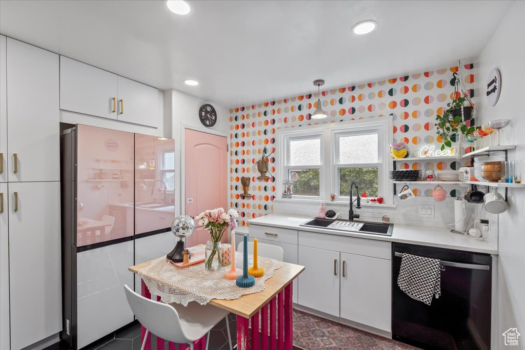 Kitchen with dishwashing machine, freestanding refrigerator, light countertops, white cabinets, and recessed lighting