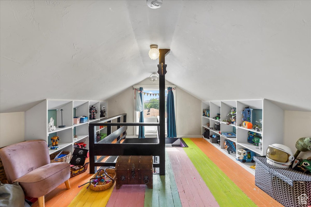 Office area featuring wood-type flooring, built in shelves, and lofted ceiling
