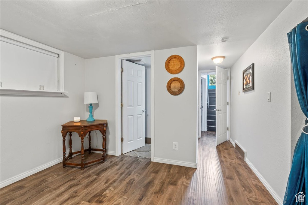 Empty room featuring wood finished floors, a textured ceiling, and a smoke detector