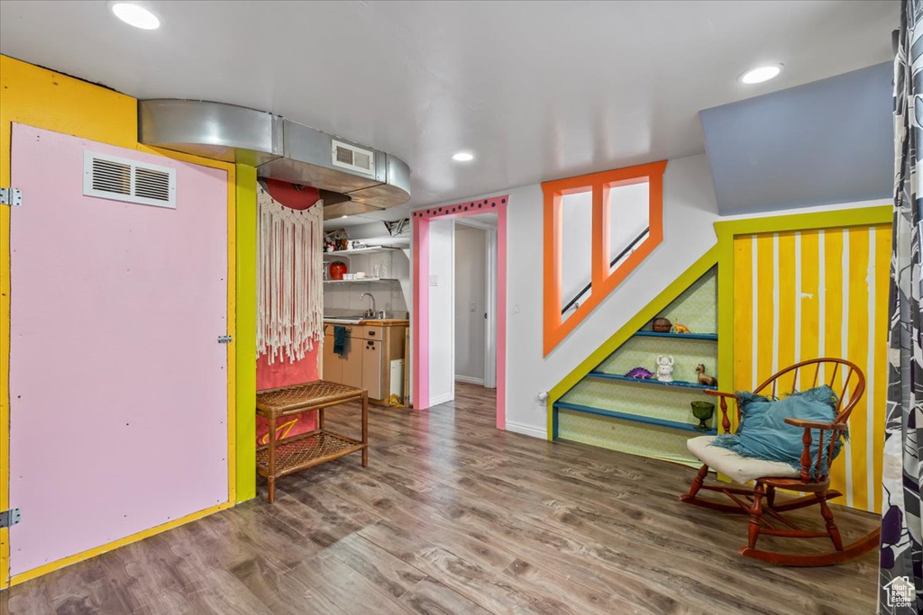 Finished basement with wood finished floors and recessed lighting