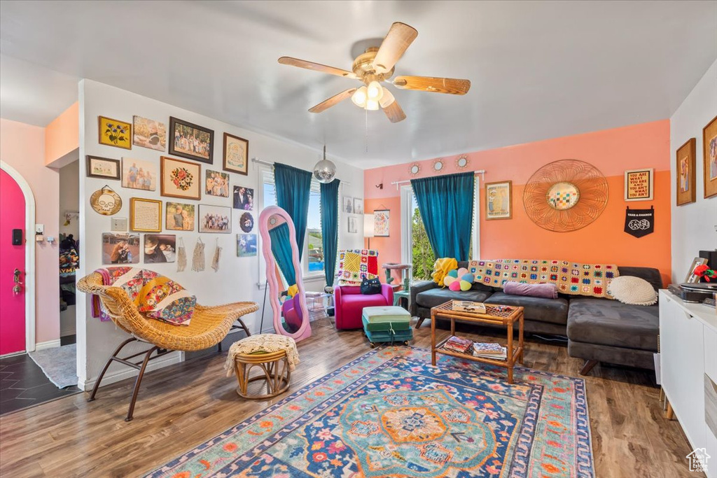 Living room featuring a ceiling fan, wood finished floors, and arched walkways