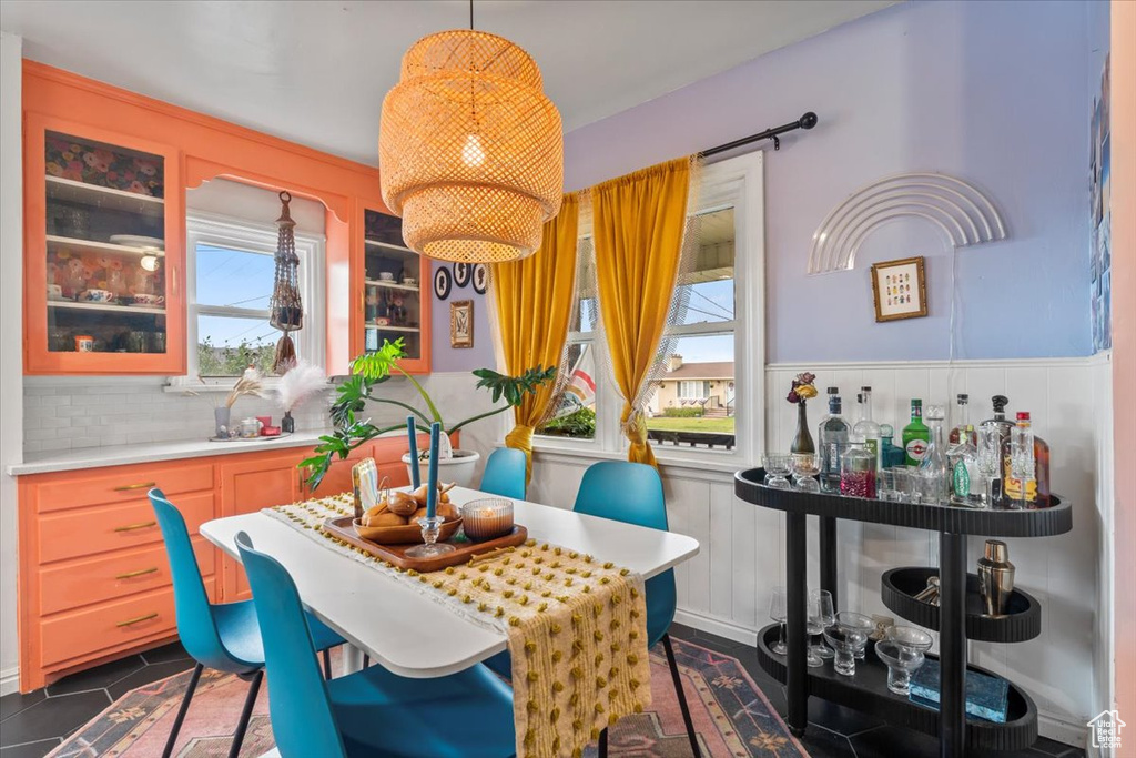 Dining space featuring wainscoting and a decorative wall