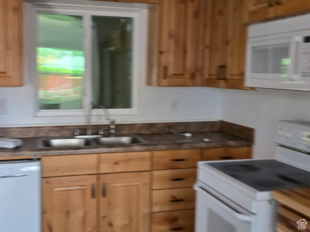 Kitchen with white appliances and dark countertops