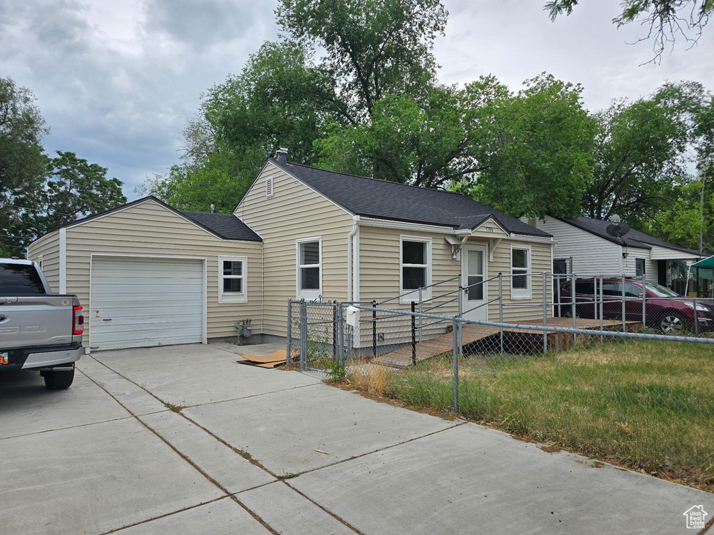 View of front of property with concrete driveway, an attached garage, and a shingled roof