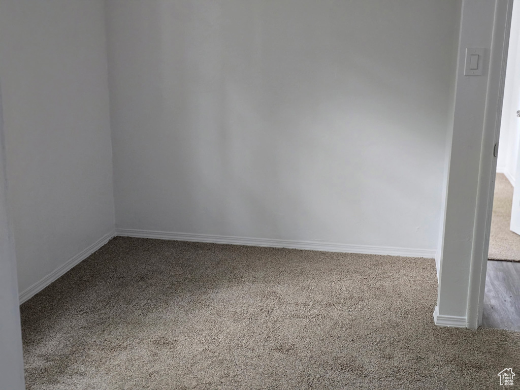 Spare room featuring carpet flooring and baseboards