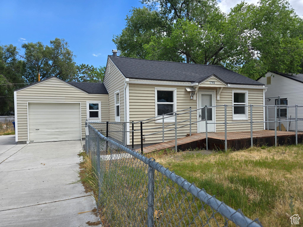 View of front of home featuring a garage, roof with shingles, and concrete driveway