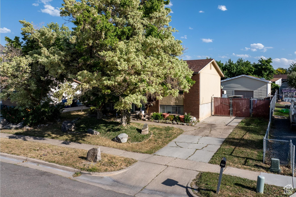 View of front of house featuring a gate, concrete driveway, a garage, and brick siding