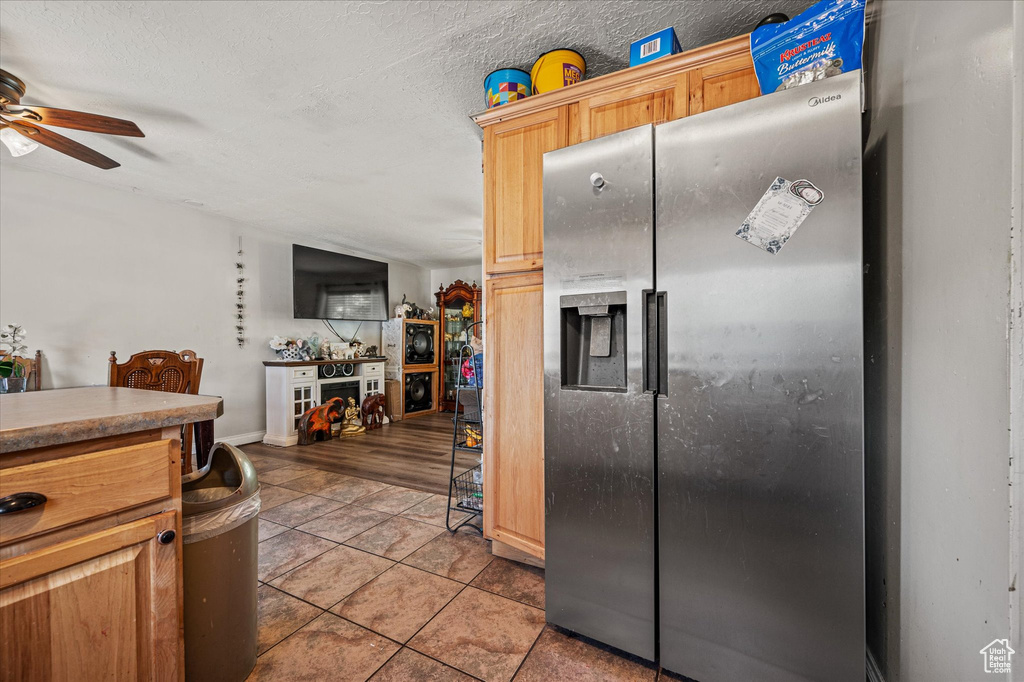 Kitchen featuring stainless steel fridge with ice dispenser, ceiling fan, and light tile patterned flooring